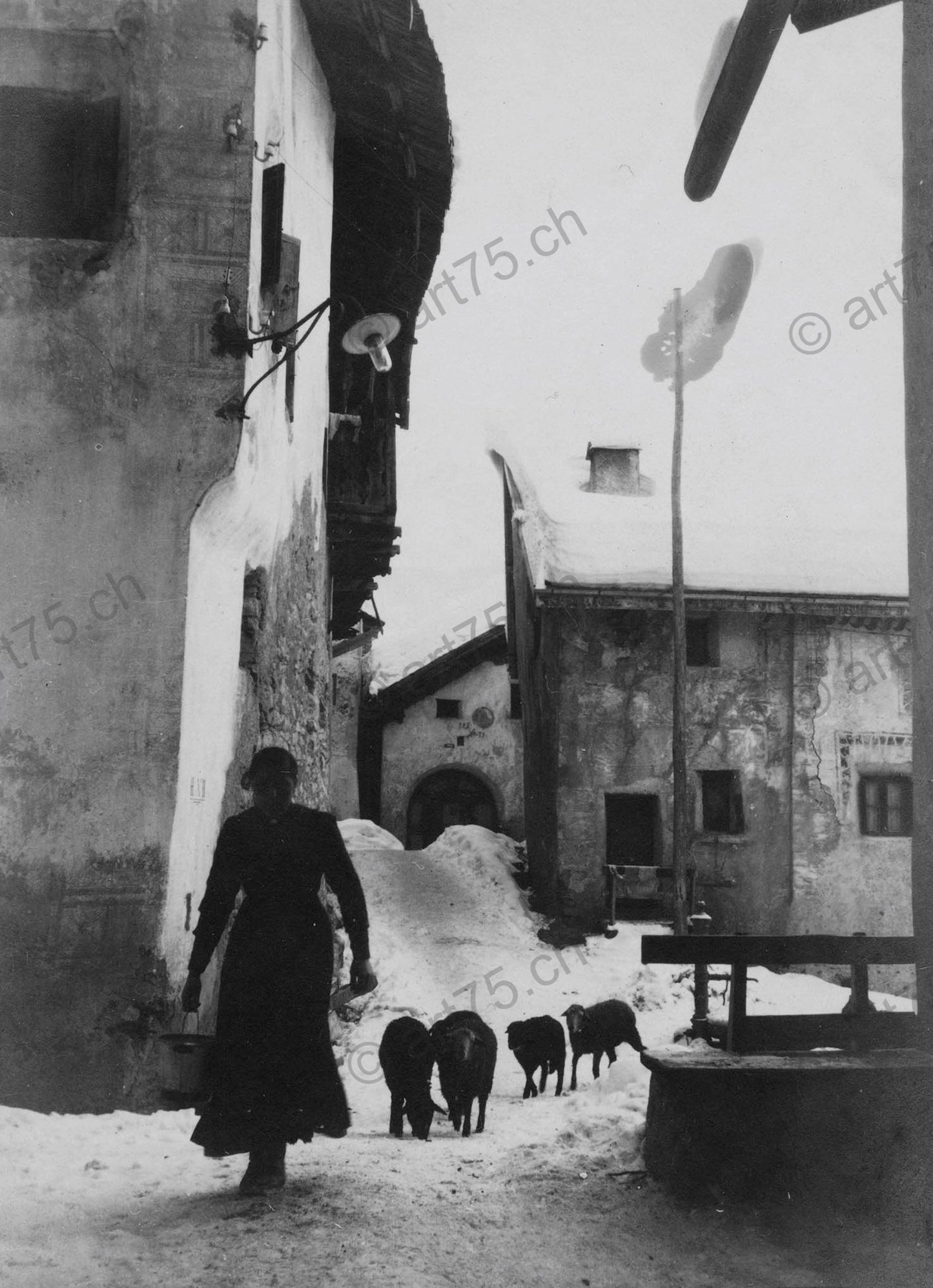 Bäuerin mit Schafen in Ardez (kühle Variante) – Historische Winterfotografie aus dem Engadin (Fine-Art Print, ca. 1920)