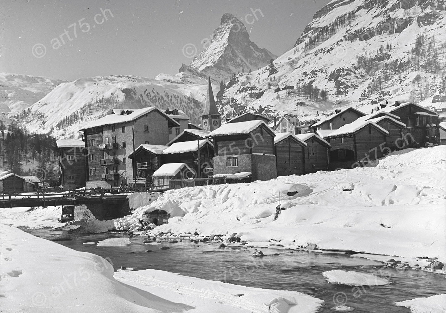 Historische Winteraufnahme von Zermatt mit Matterhorn, Speicherhäusern und verschneitem Dorfzentrum, aufgenommen um 1935.