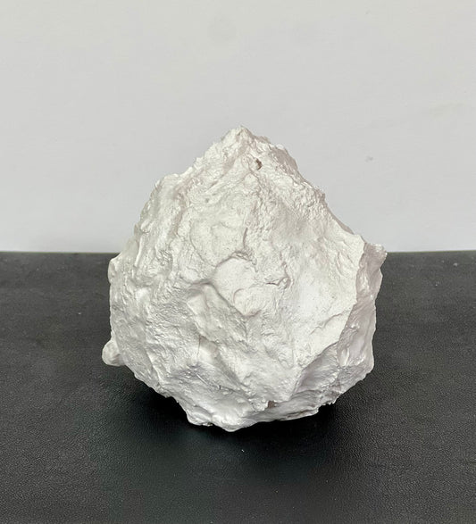 Not Vital – Schneeball, Gips-Skulptur, ca. 8 cm Durchmesser, Frontansicht auf dunklem Hintergrund.